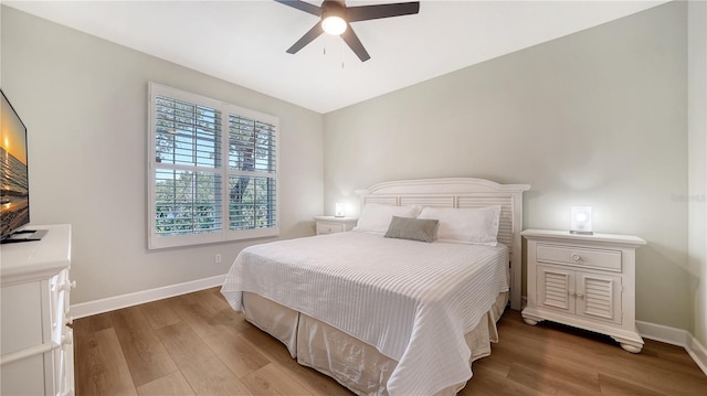 bedroom with baseboards, a ceiling fan, and wood finished floors