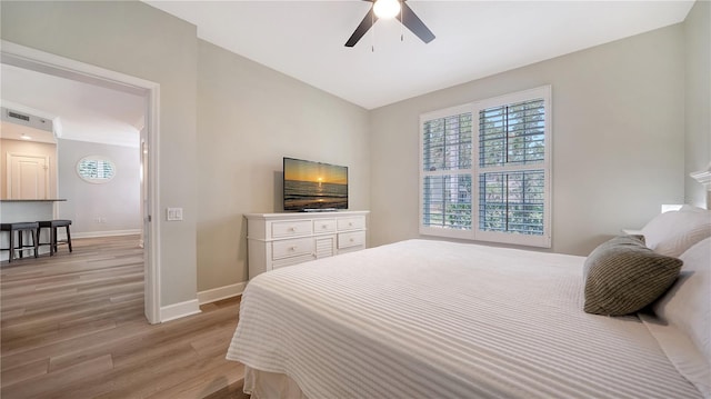 bedroom with light wood-style floors, baseboards, ceiling fan, and visible vents