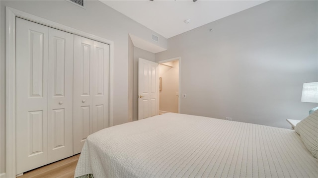 bedroom featuring a closet, light wood finished floors, and visible vents