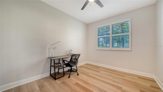 office area featuring baseboards, a ceiling fan, and light wood-style flooring