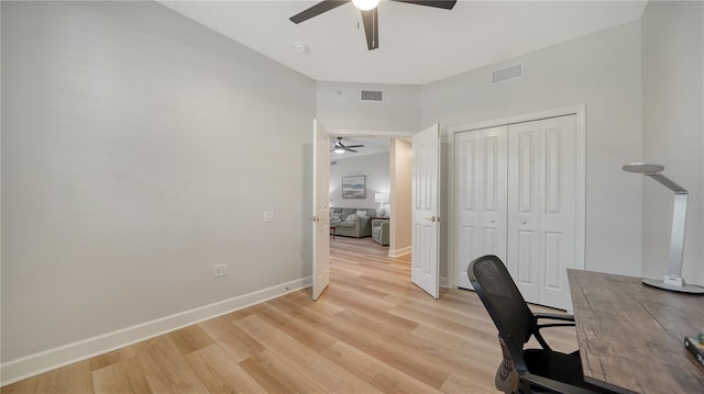 office space featuring a ceiling fan, visible vents, and light wood-type flooring