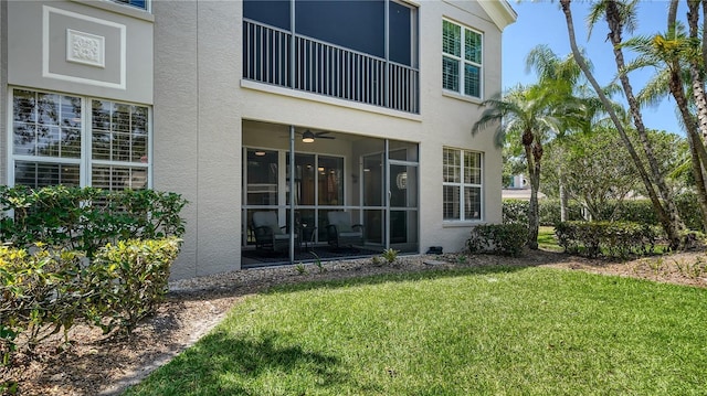 back of property with a yard and stucco siding