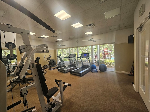 exercise room featuring a ceiling fan, baseboards, visible vents, and a paneled ceiling