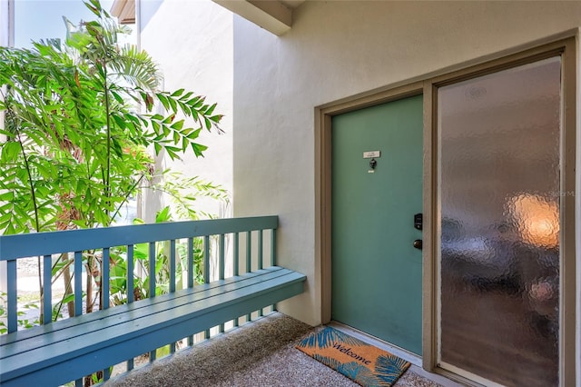 doorway to property featuring a balcony and stucco siding