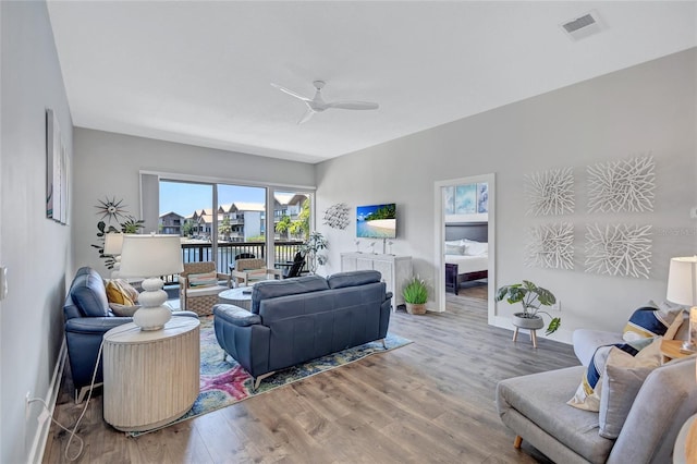 living room featuring ceiling fan, light wood-style flooring, baseboards, and visible vents