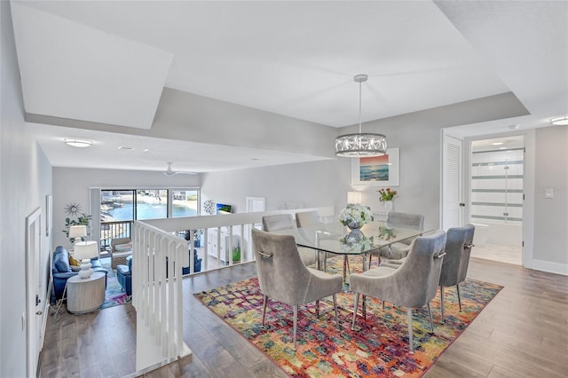 dining space featuring baseboards, a chandelier, and wood finished floors