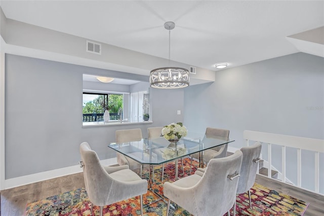 dining room featuring an inviting chandelier, visible vents, and wood finished floors