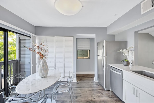 dining space with light wood finished floors, visible vents, and baseboards
