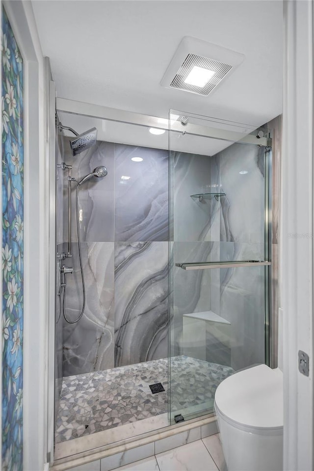 bathroom with toilet, visible vents, marble finish floor, and a stall shower