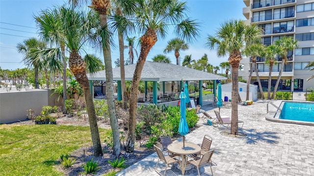 surrounding community featuring fence, a patio, a swimming pool, and a gazebo