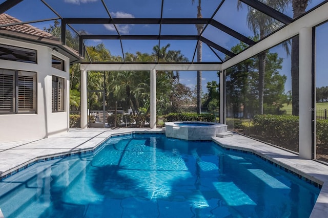 view of pool with a pool with connected hot tub, a patio area, and glass enclosure
