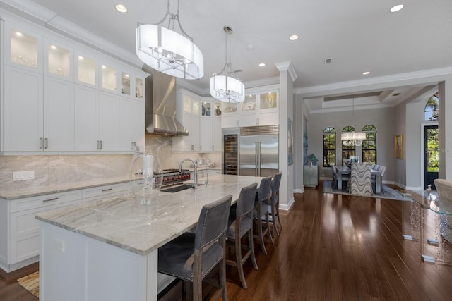 kitchen with a chandelier, built in fridge, baseboards, and a sink