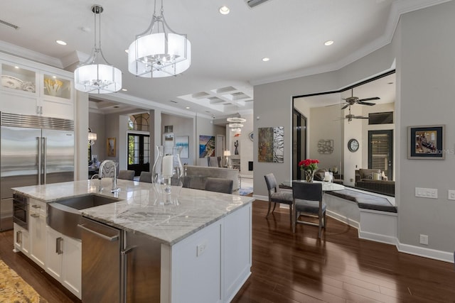kitchen with crown molding, appliances with stainless steel finishes, open floor plan, and a sink