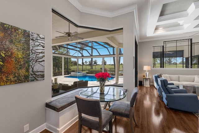 dining space with coffered ceiling, ceiling fan, a sunroom, crown molding, and wood finished floors