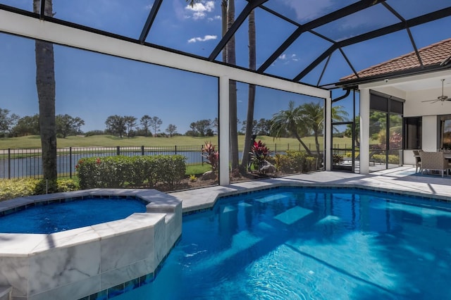 view of swimming pool with a patio, a pool with connected hot tub, fence, ceiling fan, and glass enclosure