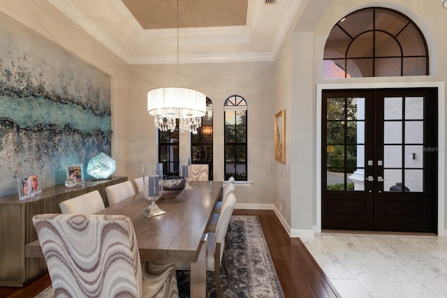 dining room with french doors, baseboards, an inviting chandelier, wood finished floors, and a raised ceiling