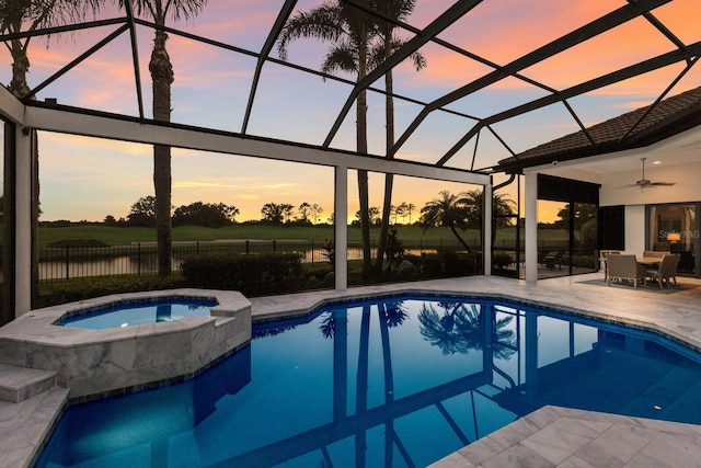 view of swimming pool featuring a pool with connected hot tub, a patio area, a lanai, and a ceiling fan