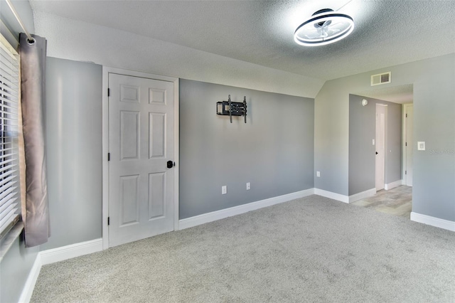 625 30th Ave W Unit G210, Bradenton, FL 34205 - empty room with light carpet, a textured ceiling, and lofted ceiling