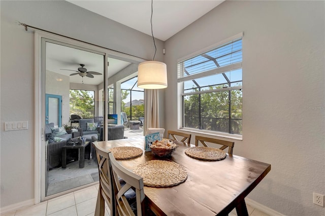dining space featuring a sunroom, light tile patterned flooring, baseboards, and a ceiling fan