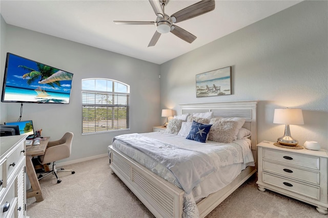 bedroom with a ceiling fan, baseboards, and light colored carpet