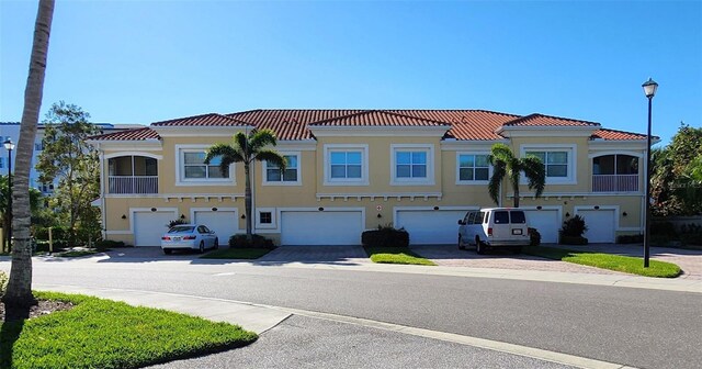 116 Navigation Cir Unit 106, Osprey, FL 34229 - townhome / multi-family property with a tiled roof, an attached garage, and driveway