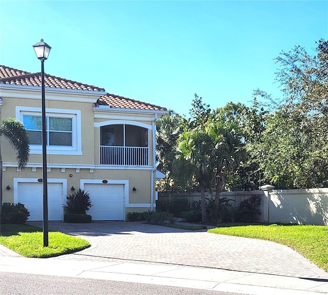 116 Navigation Cir Unit 106, Osprey, FL 34229 - view of front of house featuring stucco siding, decorative driveway, a garage, fence, and a tile roof