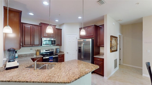 116 Navigation Cir Unit 106, Osprey, FL 34229 - kitchen featuring appliances with stainless steel finishes, a sink, a peninsula, decorative light fixtures, and light stone counters