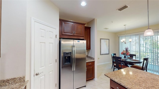 116 Navigation Cir Unit 106, Osprey, FL 34229 - kitchen featuring stainless steel refrigerator with ice dispenser, a chandelier, hanging light fixtures, baseboards, and light stone countertops