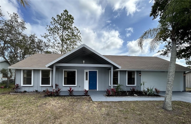 ranch-style home featuring board and batten siding, an attached garage, concrete driveway, and roof with shingles