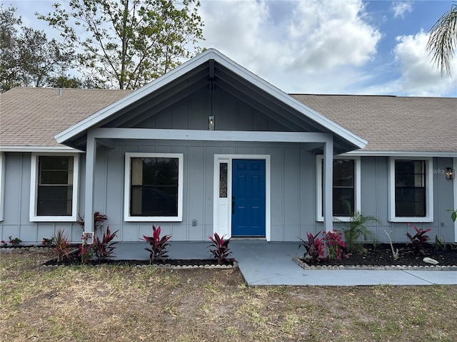 single story home featuring a shingled roof and board and batten siding