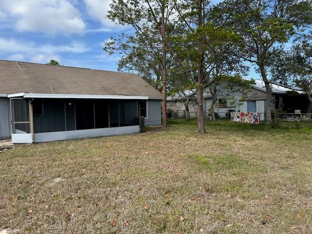 view of yard featuring fence and a sunroom