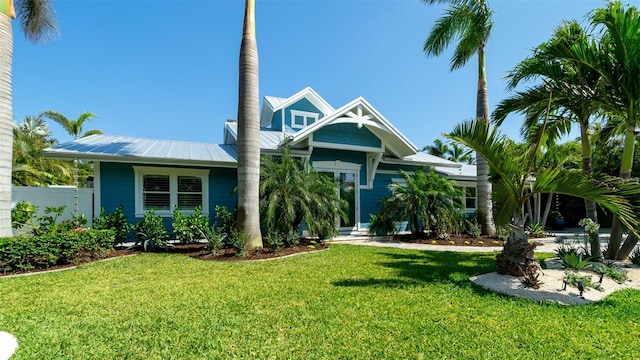 view of front of property with a front lawn, fence, and metal roof