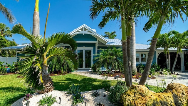 view of front of home with french doors and a front lawn