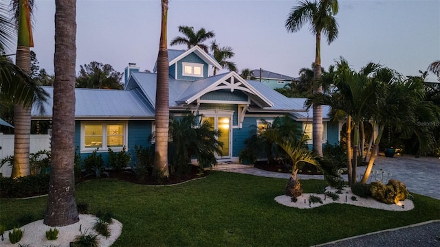 view of front of house with metal roof and a front yard
