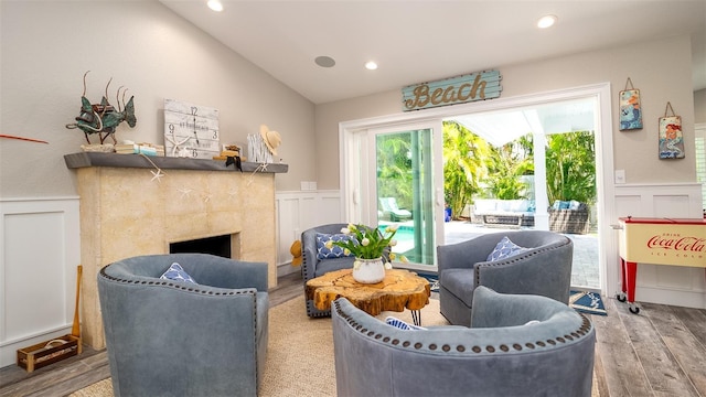 sitting room with wood finished floors, recessed lighting, wainscoting, and a decorative wall