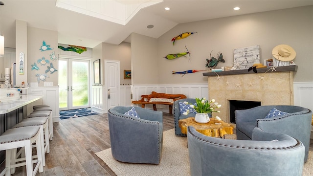 living area featuring a decorative wall, wood finished floors, and a wainscoted wall