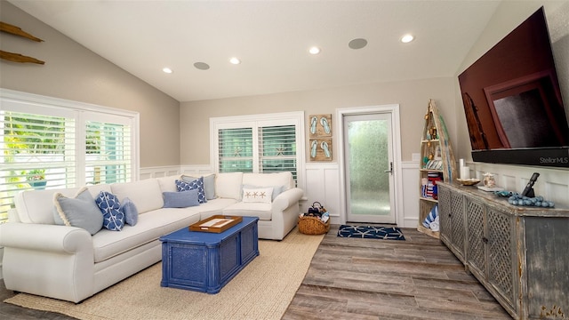living area with recessed lighting, vaulted ceiling, plenty of natural light, and a wainscoted wall