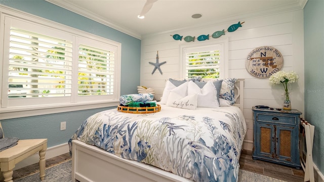 bedroom featuring ornamental molding, multiple windows, and wood finished floors
