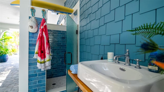 bathroom with a sink, a shower stall, and a healthy amount of sunlight