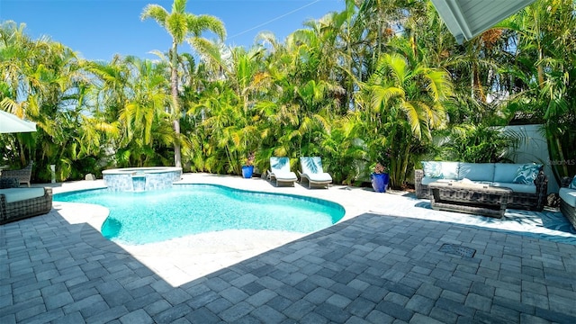 view of pool featuring an outdoor living space, a patio area, and a pool with connected hot tub