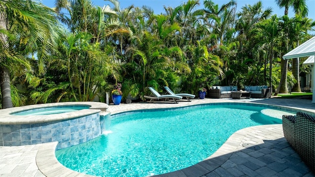 view of swimming pool with a patio, a pool with connected hot tub, and an outdoor hangout area