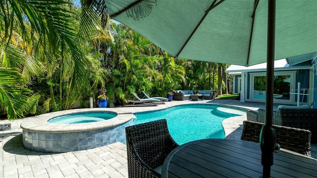 outdoor pool with an in ground hot tub, an outdoor living space, and a patio area