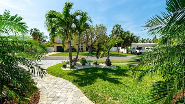 view of property's community featuring a lawn and decorative driveway