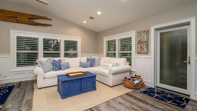 living room featuring wood finished floors, a wainscoted wall, lofted ceiling, a decorative wall, and recessed lighting