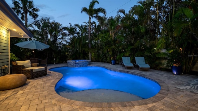 view of swimming pool featuring a pool with connected hot tub and a patio area