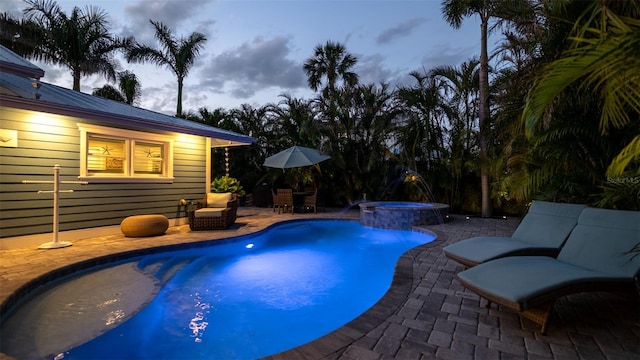 pool featuring an in ground hot tub and a patio area