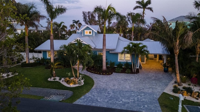 view of front of property with a front lawn, driveway, and metal roof