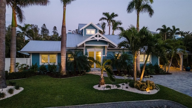 view of front facade with metal roof and a front lawn