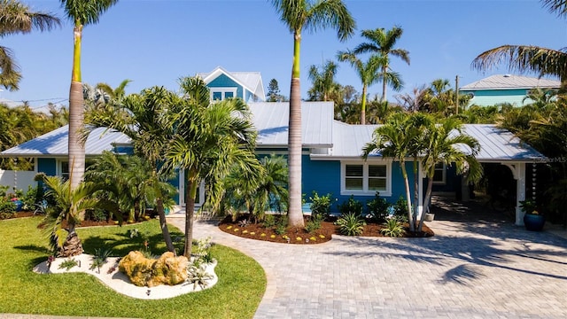 view of front of home with metal roof and curved driveway