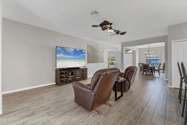 7418 61st St E, Palmetto, FL 34221 - living area with visible vents, light wood-style floors, ceiling fan with notable chandelier, and baseboards